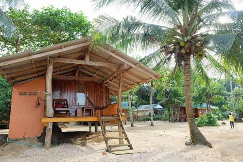 a small shack with a hammock and a palm tree at Koh Mak Green View Resort in Ko Mak