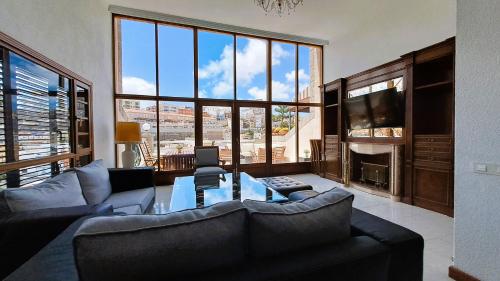 Una sala de estar con un sofá y una mesa y una ventana grande. en Vik Altavista, en Las Palmas de Gran Canaria
