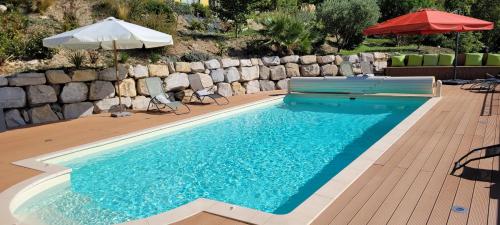 une piscine avec deux chaises et un parasol dans l'établissement Le Jas de Volonne, à Volonne