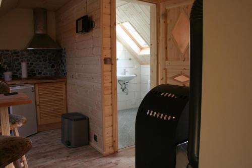 uma cozinha com uma porta aberta para uma cozinha com um lavatório em Ferienwohnung Nicklich em Berbisdorf