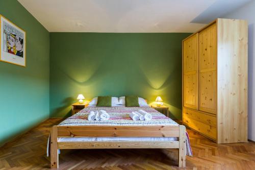 a bedroom with a large bed with green walls at Lavender apt. w. balcony in old town in Zadar