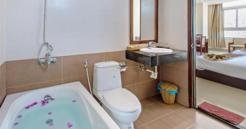 a bathroom with a tub and a toilet and a sink at Sunview Beach Hotel Danang in Da Nang