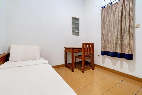 1 dormitorio con 1 cama, 1 mesa y 1 silla en OYO Life 92589 Geusan Ulun Residence en Bandung