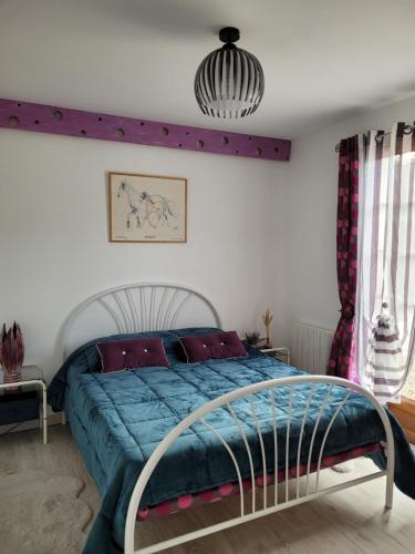 une chambre avec un lit avec une couette bleue dans l'établissement Charmante maison, à Lacs