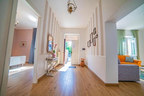 a living room with an orange couch and wooden floors at Alloggio Turistico Pietrafitta in Grotte Santo Stefano