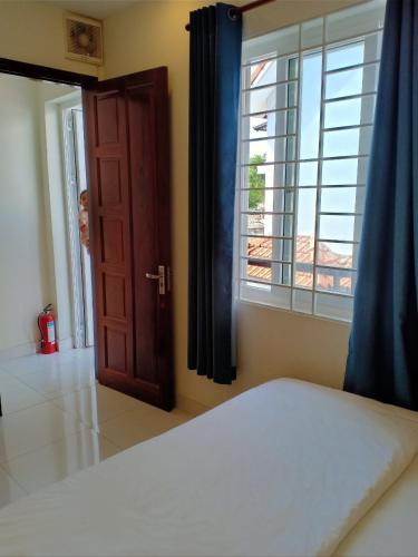 um quarto com uma cama, uma janela e uma porta em Nhà Nghỉ Linh Quân 1 em Vung Tau