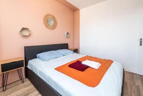 a bedroom with a large bed with an orange blanket at LE SAINT CLEMENT B AVEC SALLE DE SPORT in Rouen