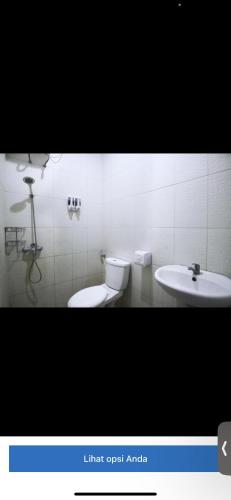 uma casa de banho com um WC e um lavatório em Reza homestay em Kubang