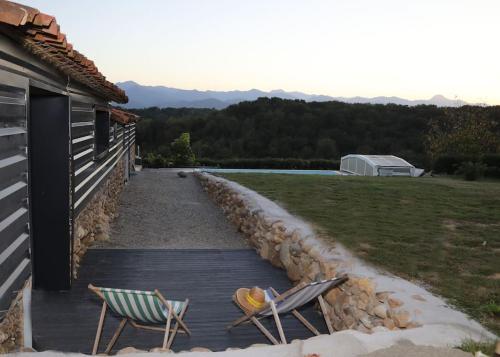 dos sillas sentadas en una terraza junto a una casa en Domaine Ostau Montplaisant, en Ponlat-Taillebourg