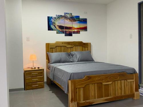 sypialnia z drewnianym łóżkiem i szafką nocną w obiekcie Apartestudios del Sol Montelibano w mieście Montelíbano