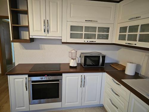 a kitchen with white cabinets and a blender at Dardania-Home in Prizren