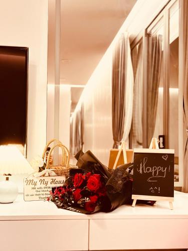 a bouquet of roses on a counter with a happy anniversary sign at Homestay My Ny Đà Lạt in Khu Chi Lăng