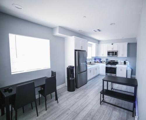 a kitchen with a black table and a refrigerator at PODLIFE in Los Angeles