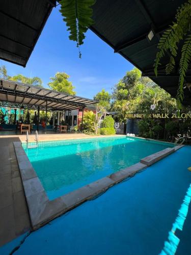 a swimming pool in a villa with blue water at ยูสีเกด รีสอร์ท in Si Sa Ket