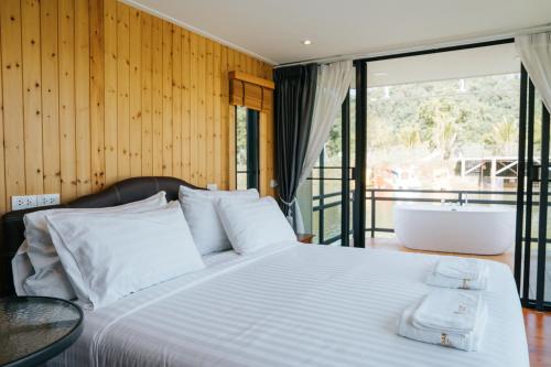 um quarto com uma cama com uma banheira e uma janela em Chiangrung Park 