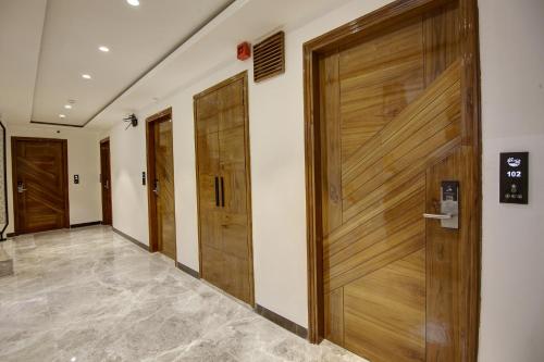 a corridor with wooden doors in a building at Hotel Kaca Inn-Traveller's Choice Awarded Best of the Best 2025 in New Delhi