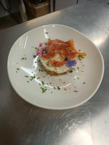 a white plate with food on a table at Lou Rosé in Donnas