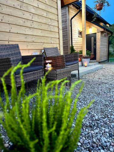 a patio with chairs and plants in front of a house at Siedlisko Złota Góra domki całoroczne na Kaszubach in Brodnica