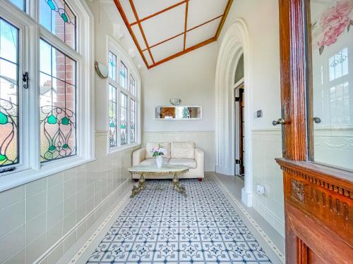 a hallway with a table in a room with windows at *RG9bC* For your most relaxed & Cosy stay + Free Parking + Free Fast WiFi * in Moortown