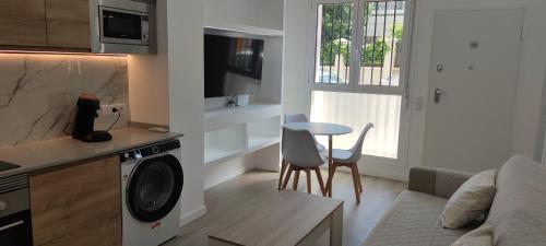 uma cozinha e sala de estar com uma máquina de lavar roupa e uma mesa em Precioso apartamento de diseño para 4-6 personas VT-55212-V em Valência