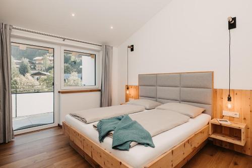 a large bed in a room with a large window at Ferienappartement Bergliebe in Grossarl