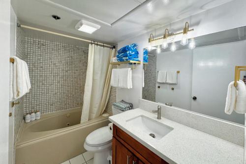 uma casa de banho com um lavatório, uma banheira e um WC. em 1BR Ocean Sunset View With Parking em Honolulu