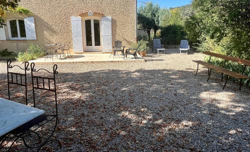 a patio with benches and a table and chairs at Gite Harmonie in Gréoux-les-Bains