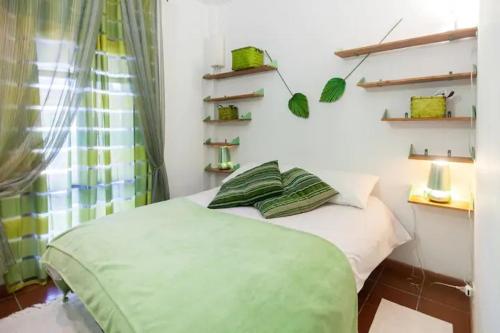 a bedroom with a bed with a green blanket at Borgo Caere in Ladispoli