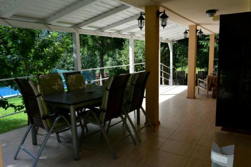 a patio with a table and chairs on a porch at Casa Aris Lepsa Vrancea in Lepşa