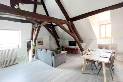 un salon avec une table et un canapé dans l'établissement Charme plein cœur Auxerre - parking privé, à Auxerre