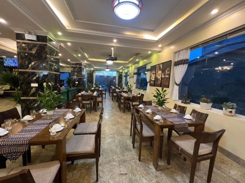 a restaurant with wooden tables and chairs and a large aquarium at Sapa Adam Hotel in Lao Cai