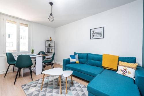 un salon avec un canapé bleu et une table dans l'établissement Le Garden B avec salle de sport, à Rouen