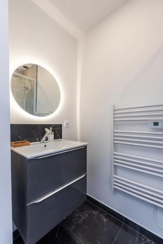 une salle de bain avec un lavabo et un miroir dans l'établissement Le Garden B avec salle de sport, à Rouen