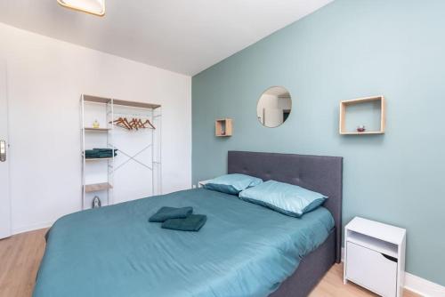 - une chambre dotée d'un grand lit avec des draps bleus dans l'établissement Le Garden B avec salle de sport, à Rouen