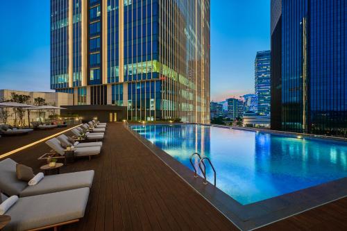 台北的住宿－台北漢來大飯店，大楼内一个带躺椅的游泳池
