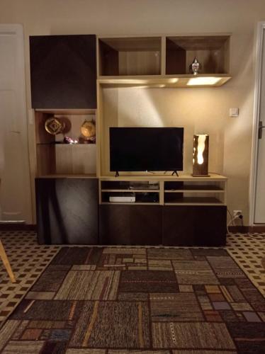 un salon avec une télévision à écran plat sur un mur dans l'établissement Les Acacias - Maison Orly, à Orly