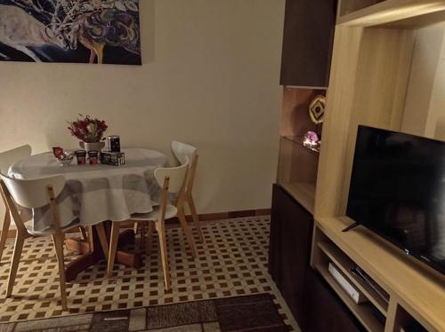a small dining room with a table and a tv at Les Acacias - Maison Orly in Orly