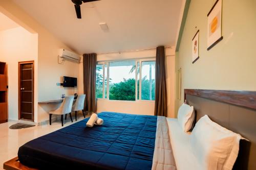 a bedroom with a large bed with a blue blanket at Commune18 Resort Chikmagalur in Chikmagalūr