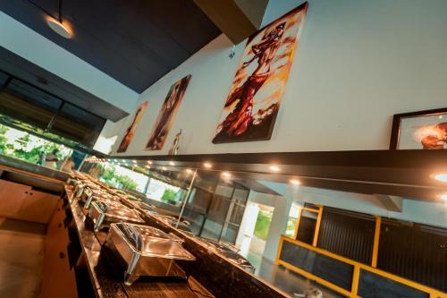 a restaurant with a row of tables in a room at Commune18 Resort Chikmagalur in Chikmagalūr
