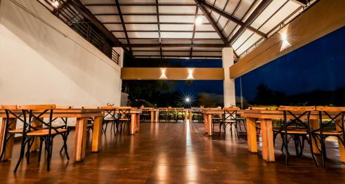 a row of wooden tables and chairs in a building at Commune18 Resort Chikmagalur in Chikmagalūr