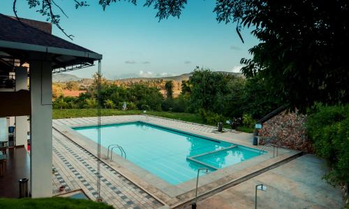 a large swimming pool with blue water in a yard at Commune18 Resort Chikmagalur in Chikmagalūr