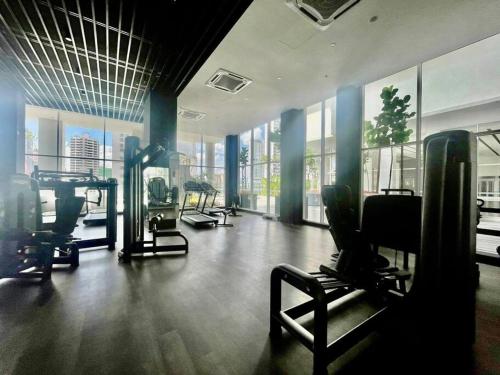 um ginásio com vários equipamentos de exercício numa sala com janelas em Quill Residences em Kuala Lumpur