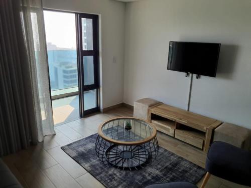 a living room with a tv and a coffee table at Oceans Lux 1 Bedroom - Seaview in Durban