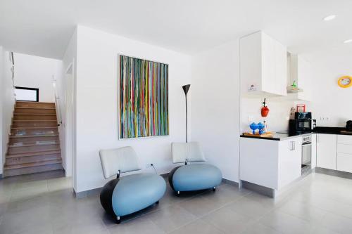 two chairs in a kitchen with a painting on the wall at Villa 33 Silver Coast in Nadadouro