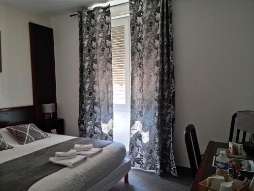 a bedroom with a bed with black and white curtains at Logis Hotel Schaeffer- Restaurant Le Saint Georges in Serrières
