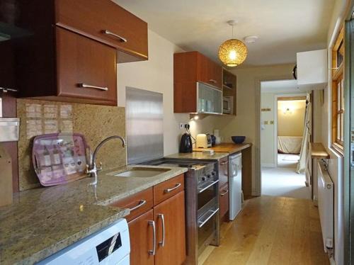 a kitchen with a sink and a stove top oven at Country garden retreat near Henley on Thames in Rotherfield Peppard