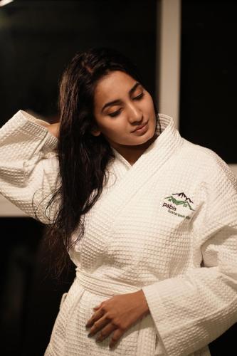 a woman wearing a white sweater with her arms crossed at Pabis luxurious stay in Vythiri