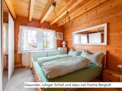 ein Schlafzimmer mit einem Bett in einer Holzhütte in der Unterkunft Chalet Müsli in Wildhaus