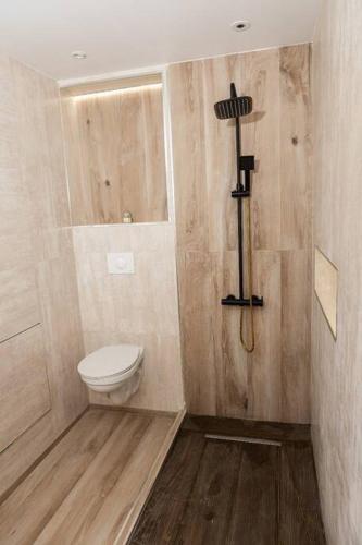 a bathroom with a toilet and a cross on the wall at Villa F4 chic avec jacuzzi en Martinique in Le Lamentin