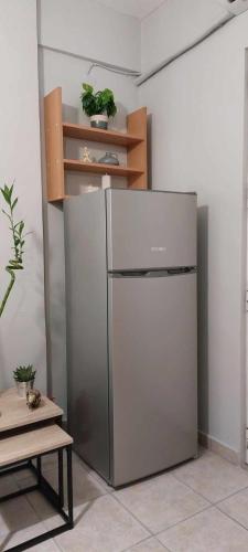 a stainless steel refrigerator in a room next to a table at Hermes Modern Apartment in Alexandroupoli